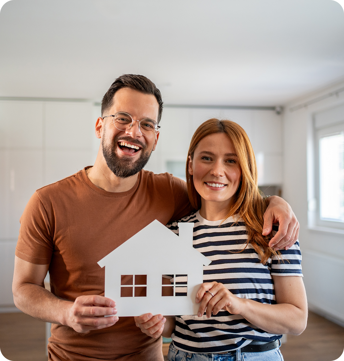 Happy couple holding house cutout